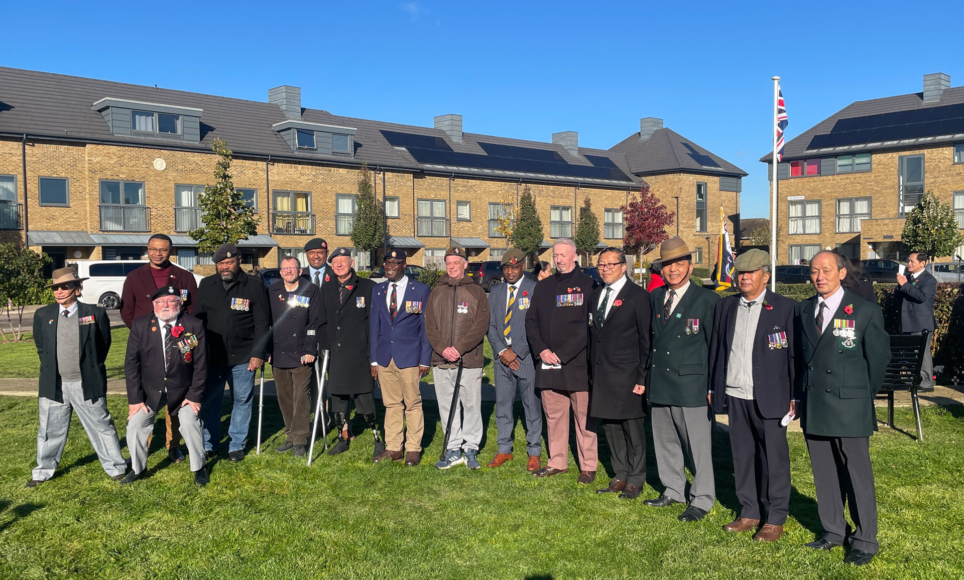 Veterans standing in a park after the raising of the flag.