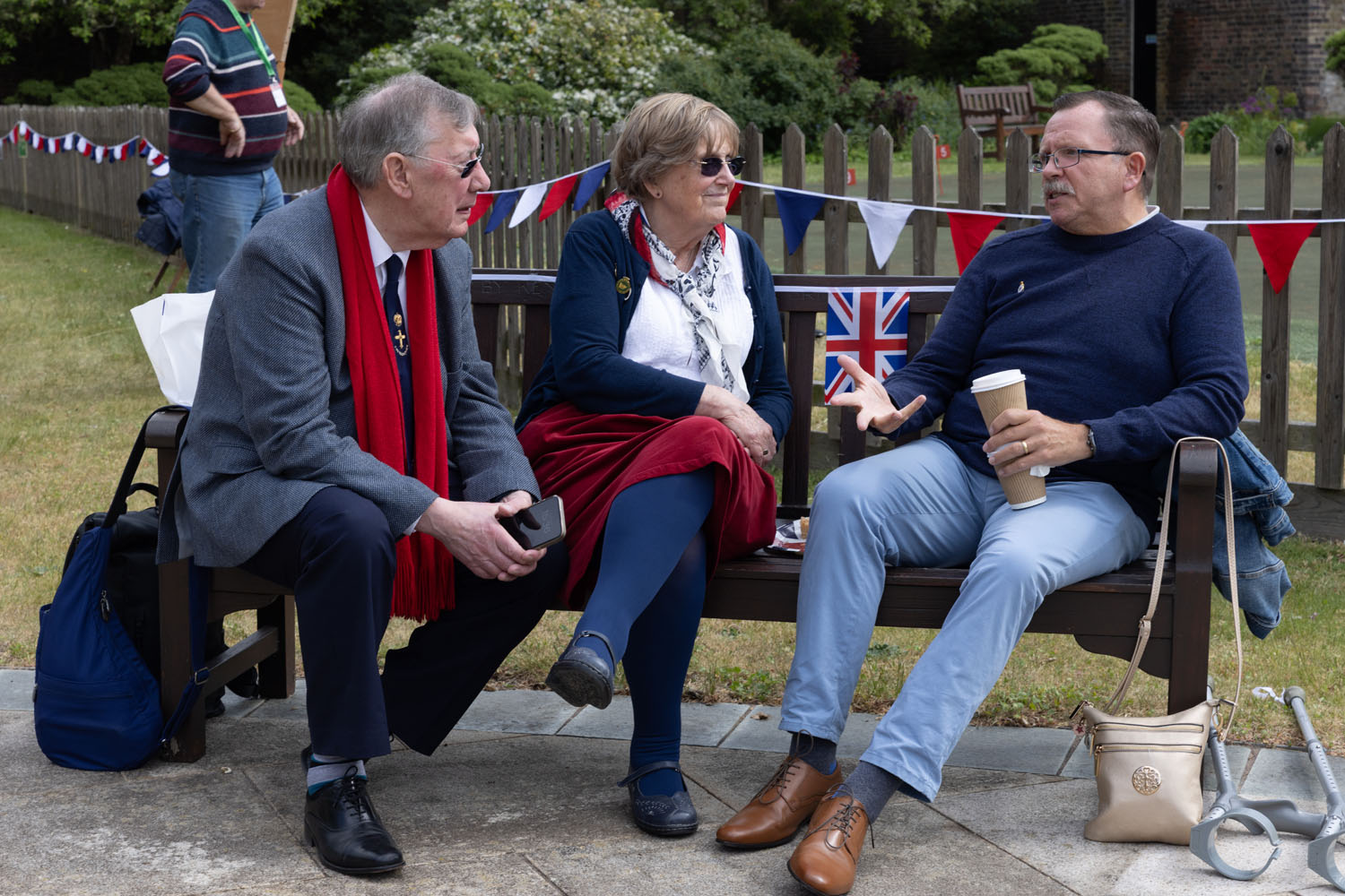 Three people sitting on a bench in a park