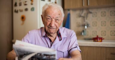 Portrait Of An Elderly Gentleman Reading Newspapers In The Kitchen